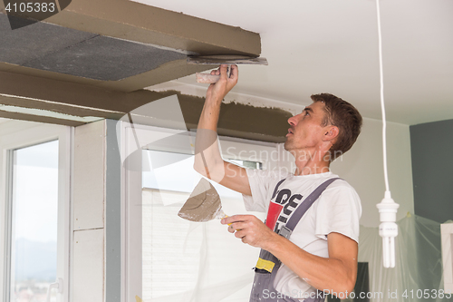 Image of Plasterer renovating indoor walls and ceilings. Finishing works.