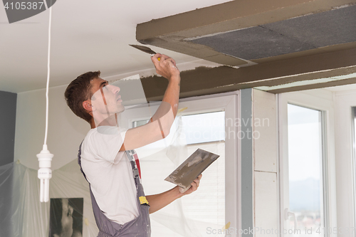 Image of Plasterer renovating indoor walls and ceilings. Finishing works.