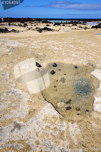 Image of people spain  hill yellow  beach  spiral of black rocks   lanzar