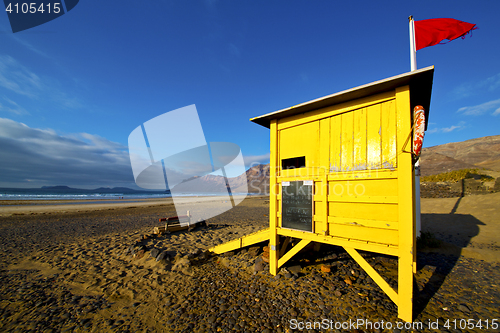 Image of water lifeguard chair cabin red flag   rock stone sky