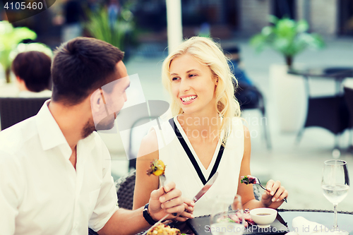 Image of happy couple eating dinner at restaurant terrace