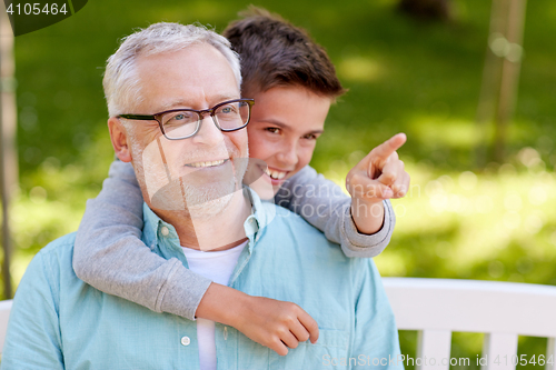 Image of grandfather and boy pointing finger at summer park