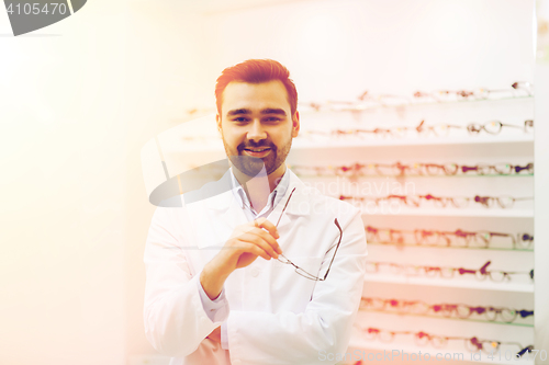 Image of man optician with glasses in coat at optics store