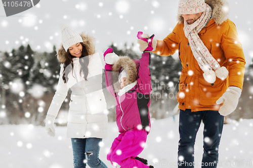 Image of happy family in winter clothes walking outdoors