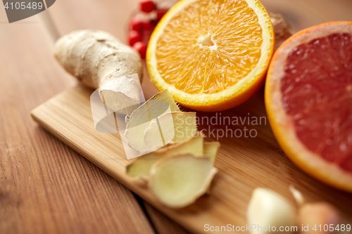 Image of citrus fruits, ginger and garlic on wood