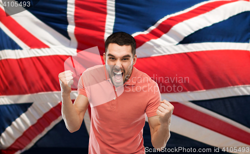 Image of angry man showing fists over brittish flag