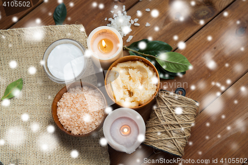 Image of natural body scrub and candles on wood
