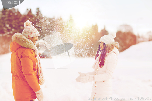 Image of happy couple playing with snow in winter