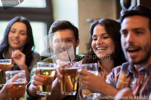 Image of happy friends drinking beer at bar or pub