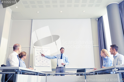 Image of group of smiling businesspeople meeting in office