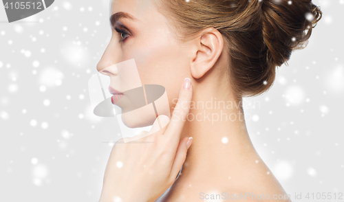 Image of close up of woman pointing finger to ear over snow