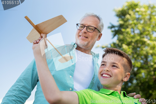 Image of senior man and boy with toy airplane over sky