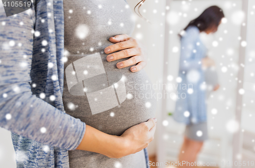 Image of close up of pregnant woman looking to mirror