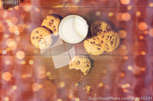 Image of christmas oat cookies and milk on wooden table