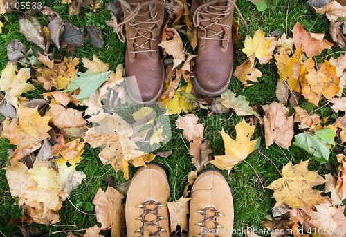 Image of couple of feet in boots and autumn leaves