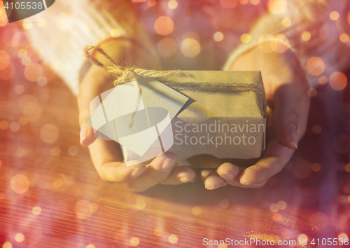 Image of close up of woman hands with christmas gift