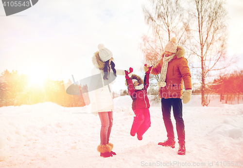 Image of happy family in winter clothes walking outdoors