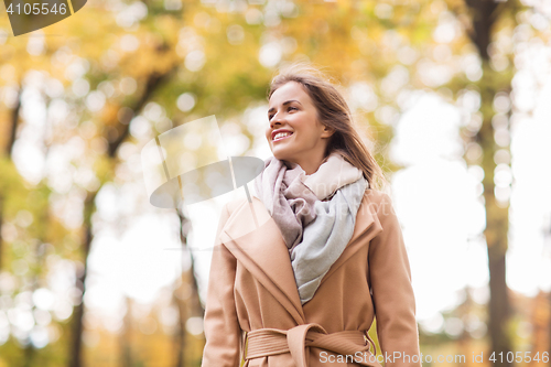 Image of beautiful happy young woman walking in autumn park