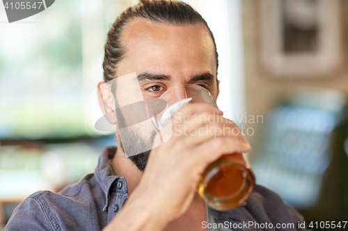 Image of close up of man drinking beer at bar or pub
