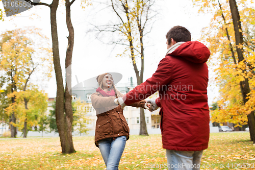 Image of happy young couple having fun in autumn park