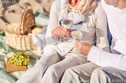 Image of happy senior couple having picnic on summer beach