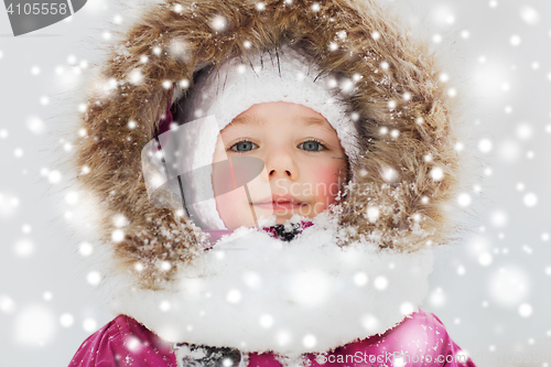 Image of face of happy little kid or girl in winter clothes