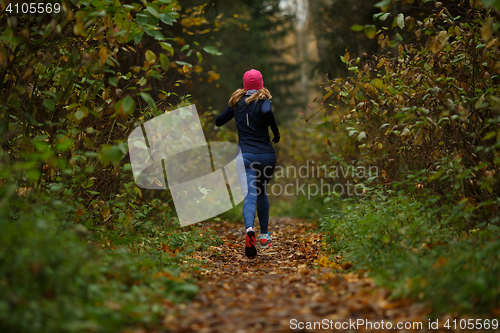 Image of Blonde woman running on trail