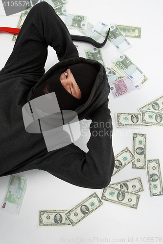 Image of Winking burglar lies with money