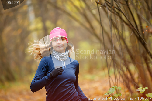 Image of Young sporty woman doing Jogging in autumn forest