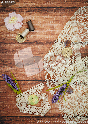 Image of Lace and thread on wooden background