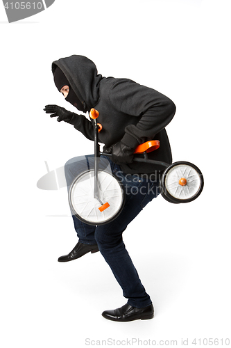 Image of Burglar sneaking small child bike