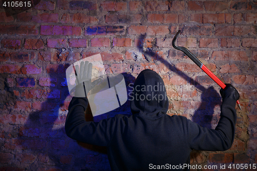 Image of Burglar standing with raised arms