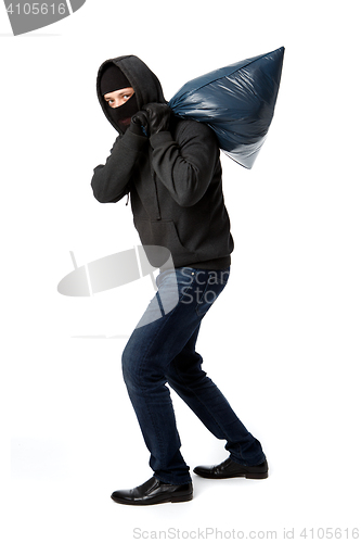 Image of Thief carries heavy big bag