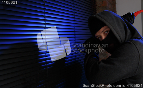 Image of Robber trying open window night