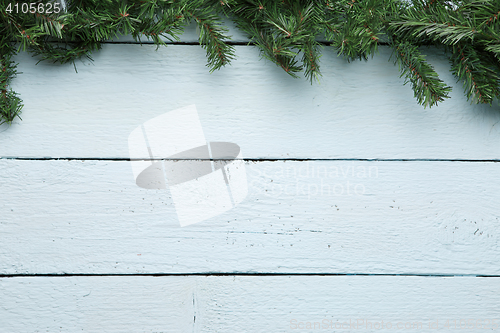 Image of Spruce branch on white wooden surface. New year, Christmas background