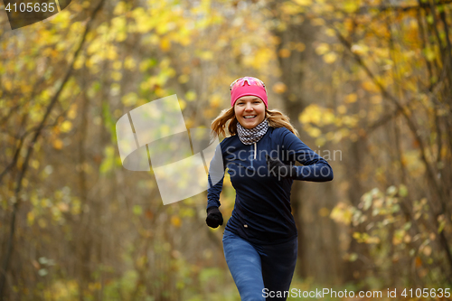 Image of Girl in sneakers among leaves