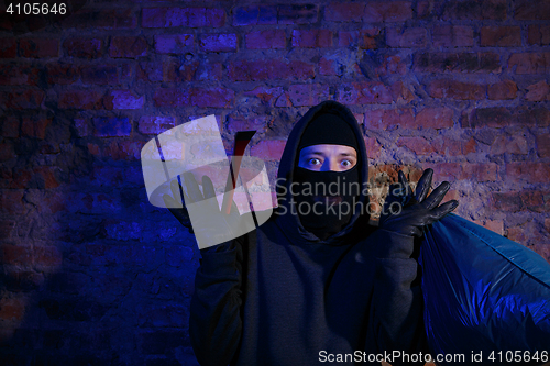 Image of Astonished bandit near brick wall