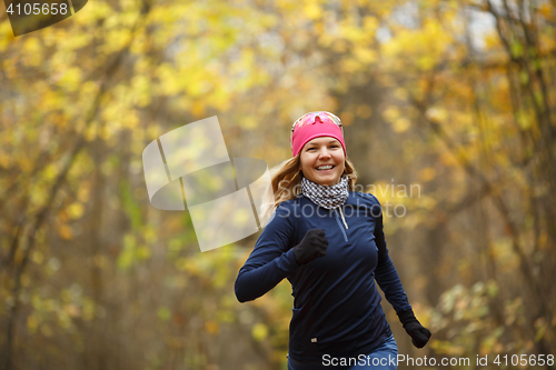 Image of Woman in sneakers among leaves