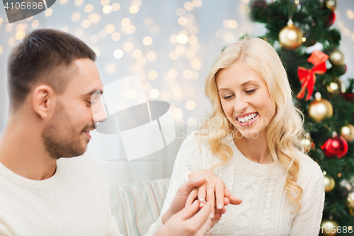 Image of man giving woman engagement ring for christmas