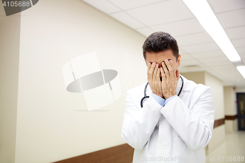 Image of sad or crying male doctor at hospital corridor