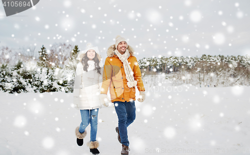 Image of happy couple walking along snowy winter field