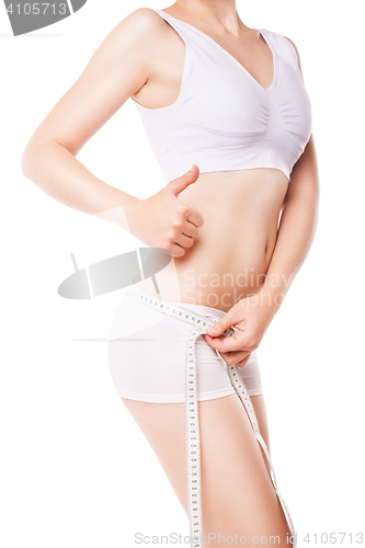 Image of Woman measuring her waist by metric tape isolated