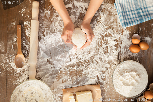 Image of Female cooking dough. View from above.