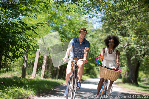 Image of Young multiethnic couple having a bike ride in nature