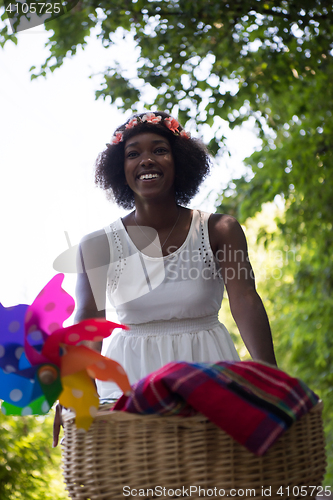 Image of pretty young african american woman riding a bike in forest