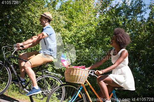Image of Young multiethnic couple having a bike ride in nature