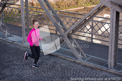 Image of sporty woman jogging on morning