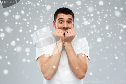 Image of scared man in white t-shirt over snow background