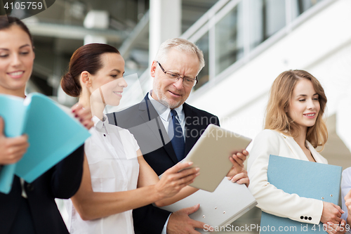 Image of business team with tablet pc and folders at office