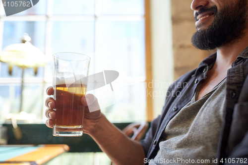 Image of close up of happy man drinking beer at bar or pub